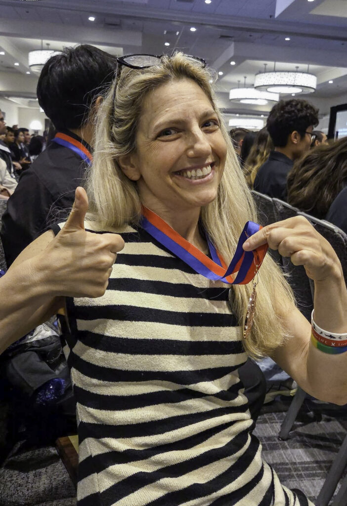 Coach Gaby Scully gives a thumbs up to the camera. 