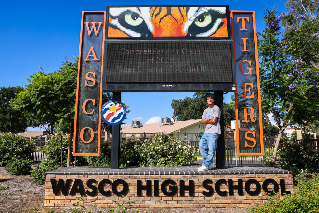 Braydon Ricks stands in front of the Wasco Union High School sign.