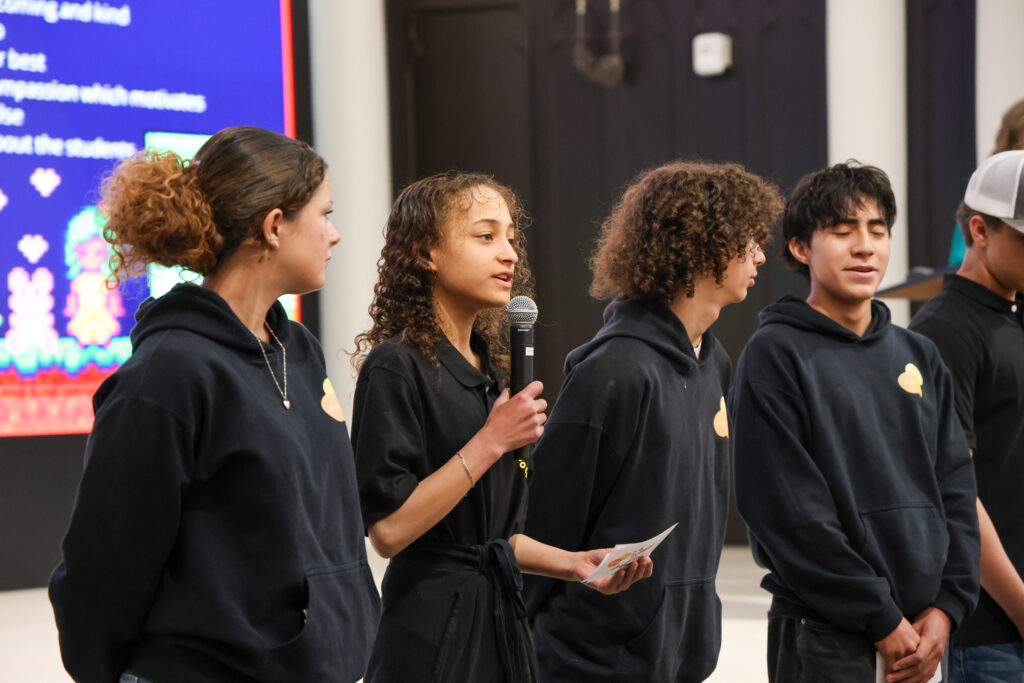 alt= "Up-close photo of students presenting their project."