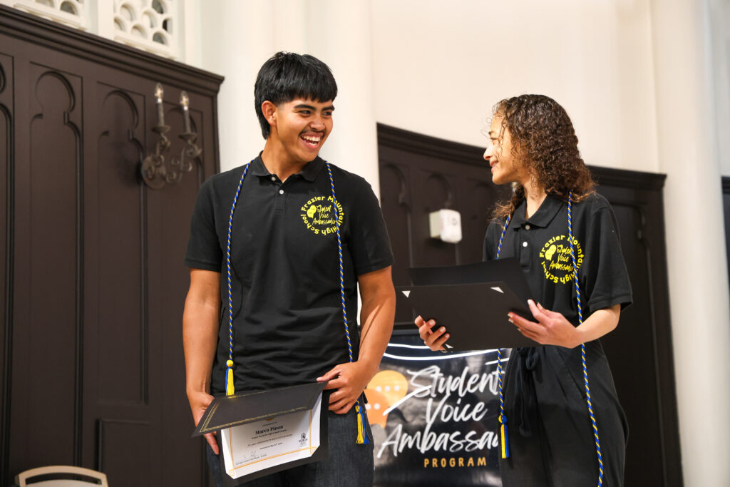 alt= "High school students smiling after receiving their cords and award certificates." 