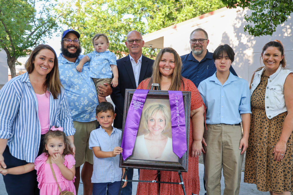 Loved ones of Tami Gibson, a former beloved KCSOS employee who passed away, pose for a photo during the 2026 Graduate Memorial Awards ceremony.