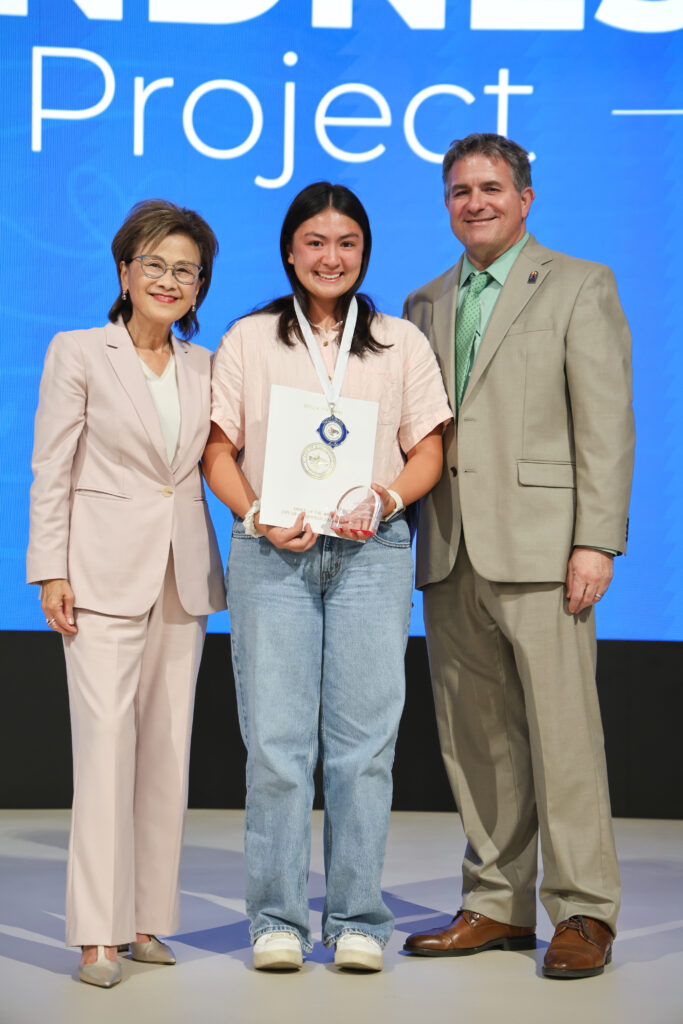 A student poses with Dr. Mendiburu and Mayor Goh.