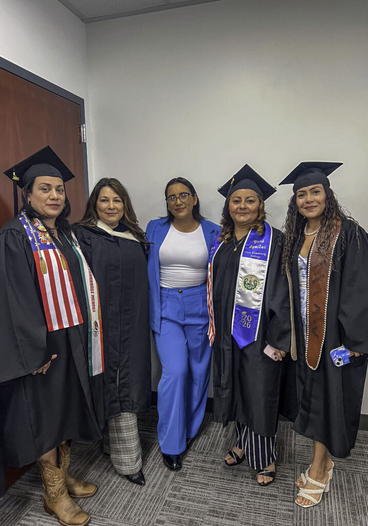 Photo of five graduates and their teachers dressed for the graduation ceremony.
