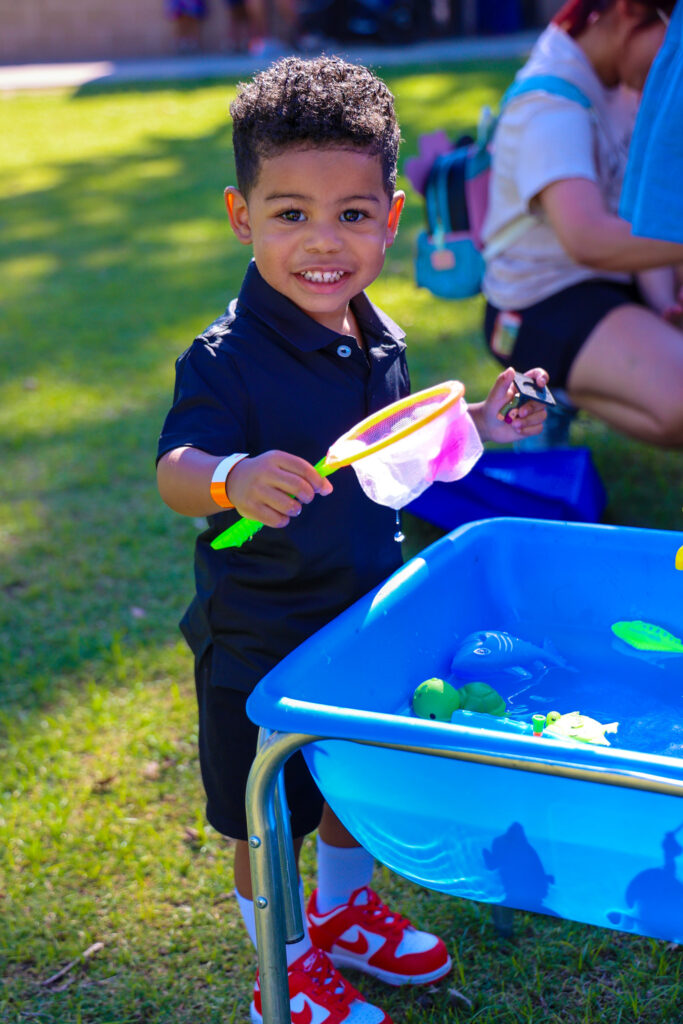 A boy plays in a water table.