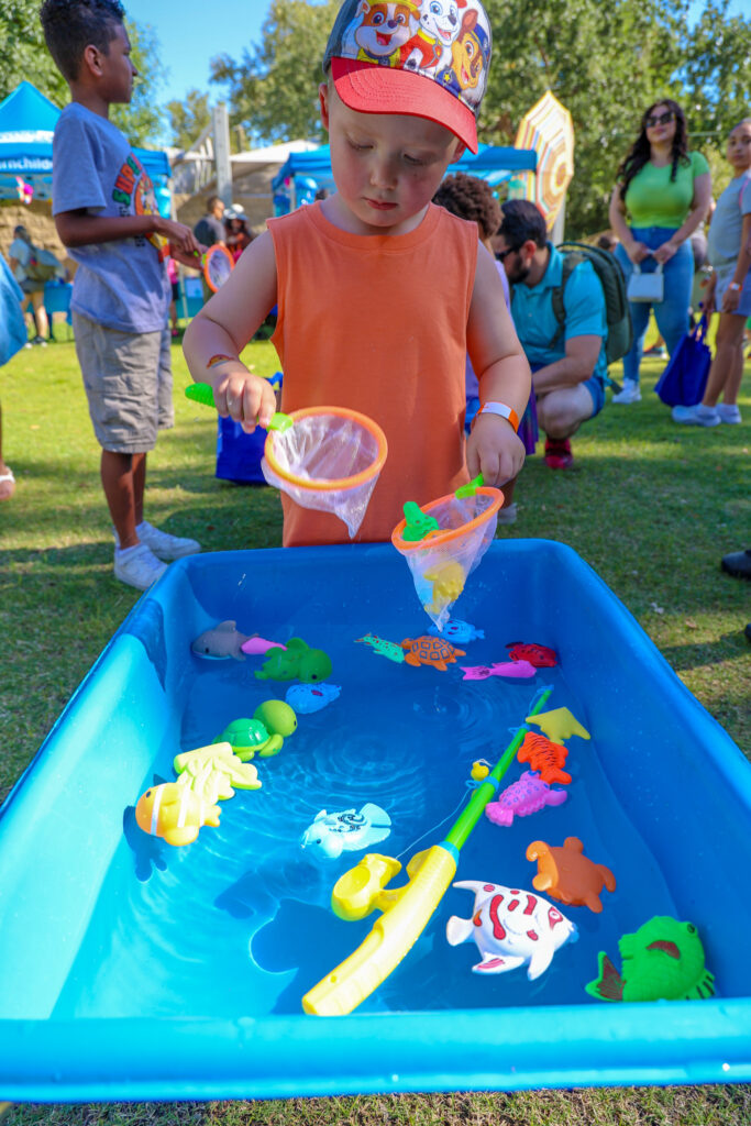 A boy plays in a water table.