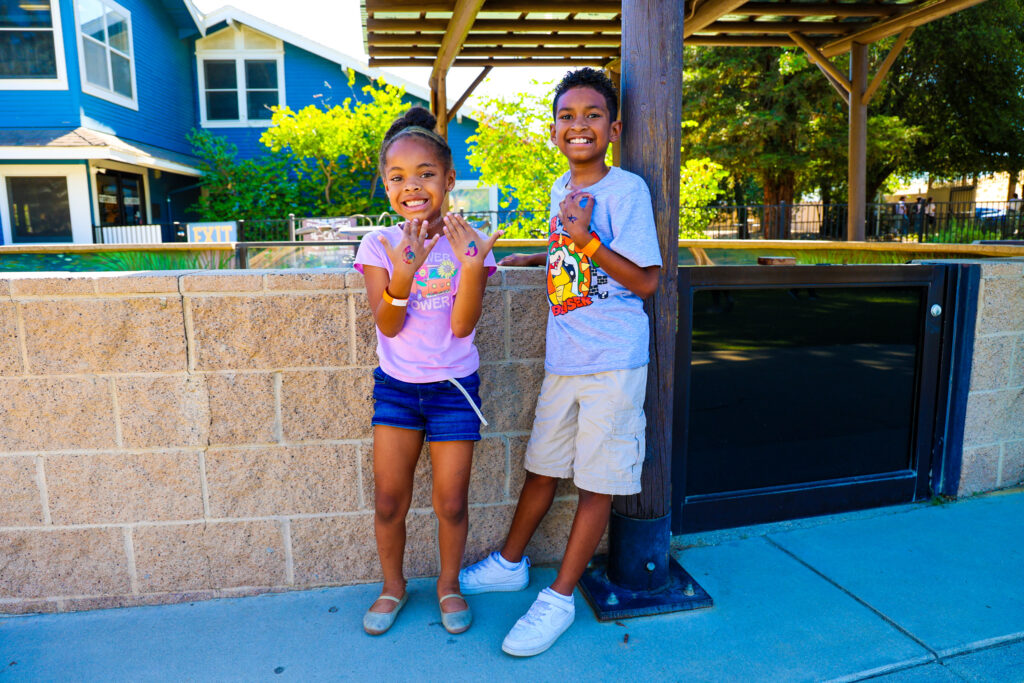 Two children smile at the camera.