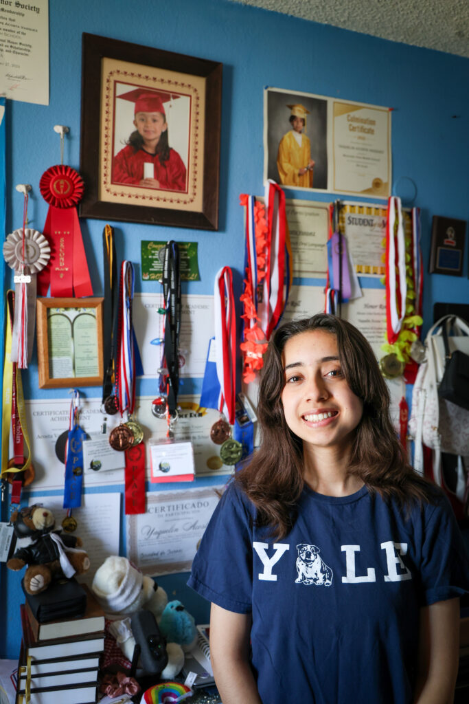 Photo of Vasquez standing in front of her wall of awards.
