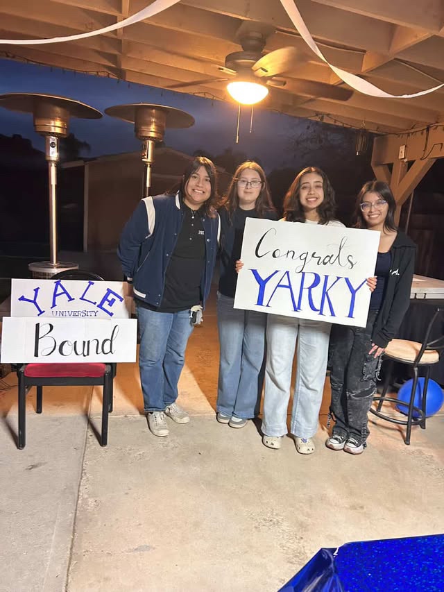Photo of Acosta Vasquez with her friends holding Yale celebration signs.