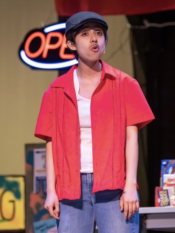 Photo of Acosta Vasquez performing dressed as Usnavi from the play In the Heights.
