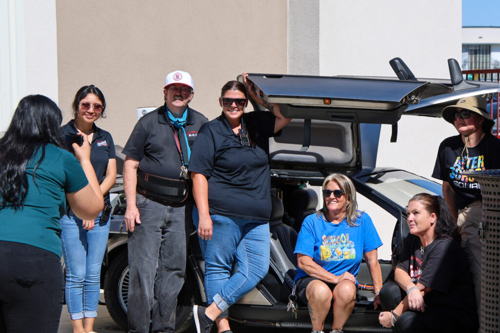 Attendees taking a photo in front of the DeLorean time machine inspired by the iconic Back to the Future films.